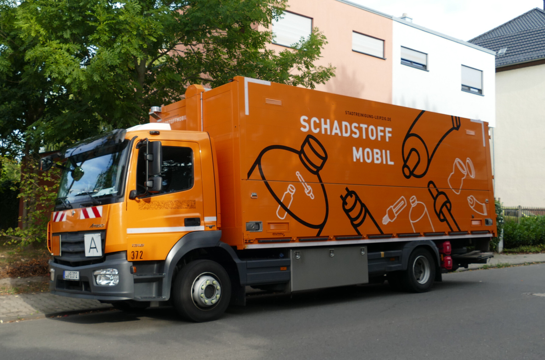 das orange Schadstoffmobil ist von der Seite zu sehen und schaut nach links