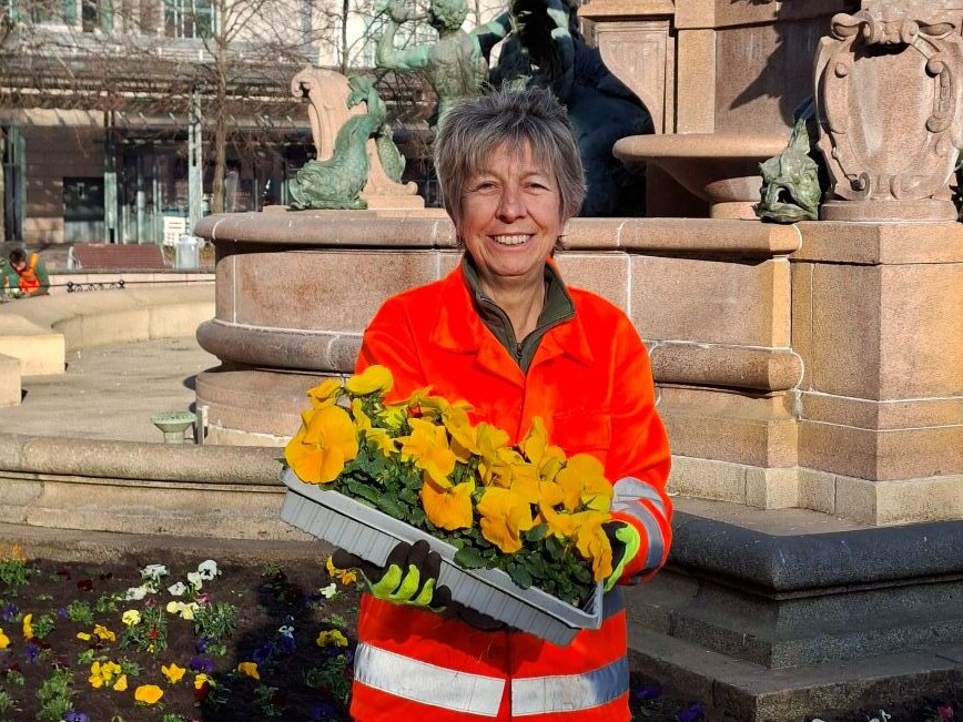 Frau mit einem Korb Fr&uuml;hjahrsblumen