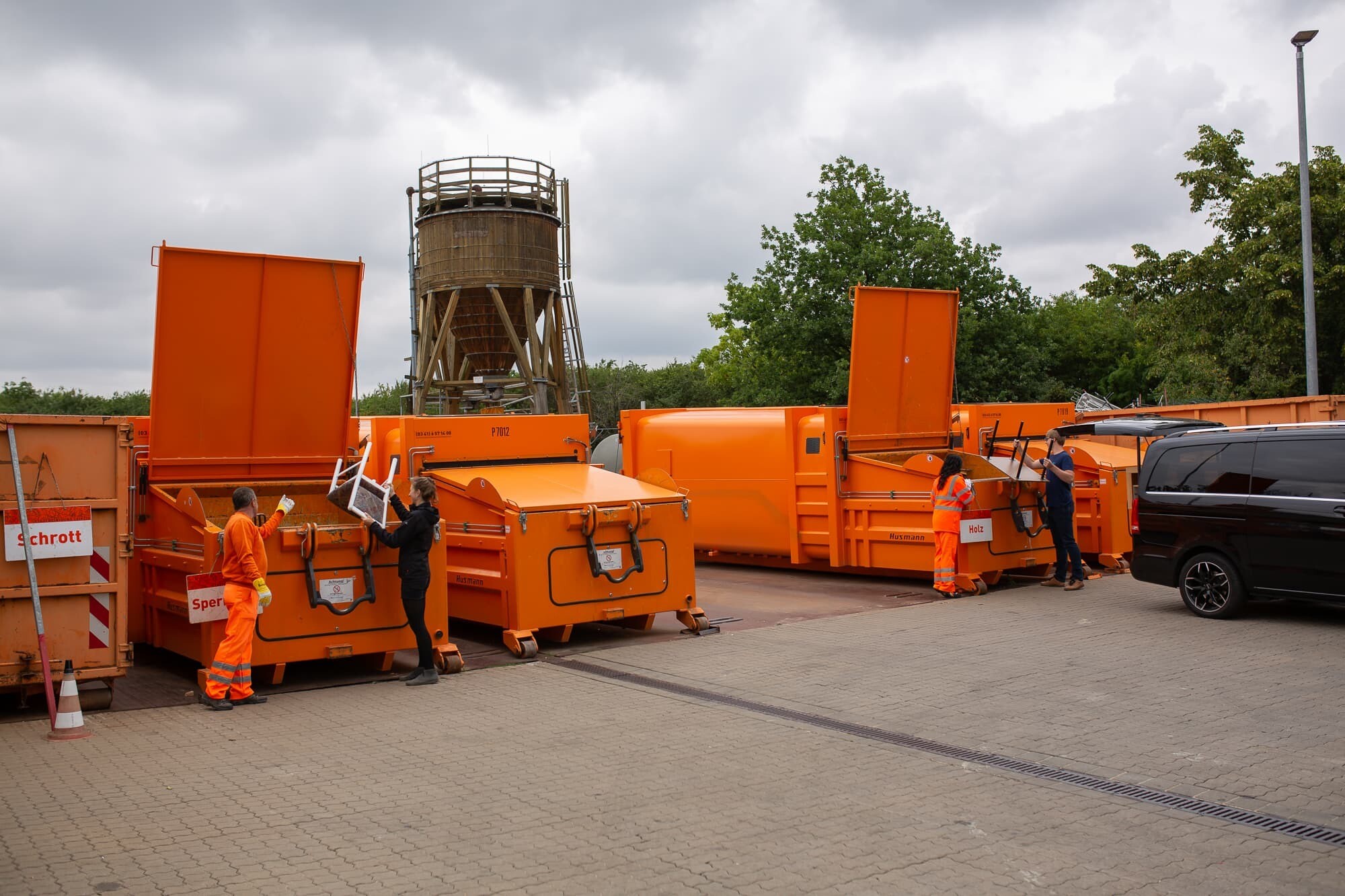 Wertstoffhof der Stadtreinigung Leipzig. Person bringt Stuhl zur Entsorgung vorbei.