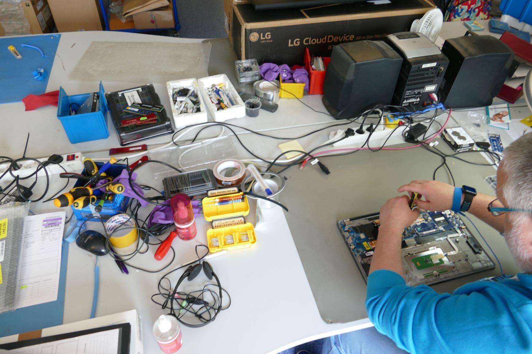 Mann arbeitet in einer Reparaturwerkstatt an Elektrogeräten.