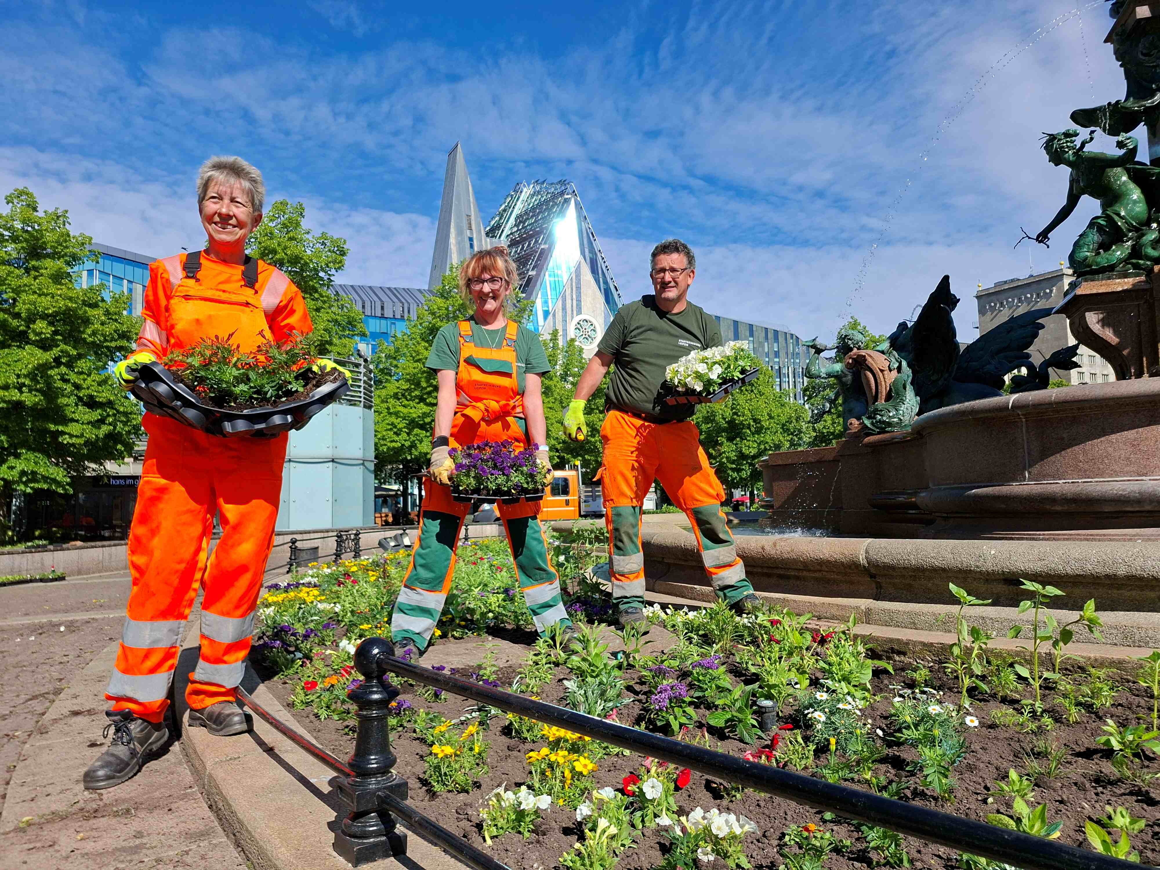 3 G&auml;rtner setzen Sommerblumen am Mendebrunnen