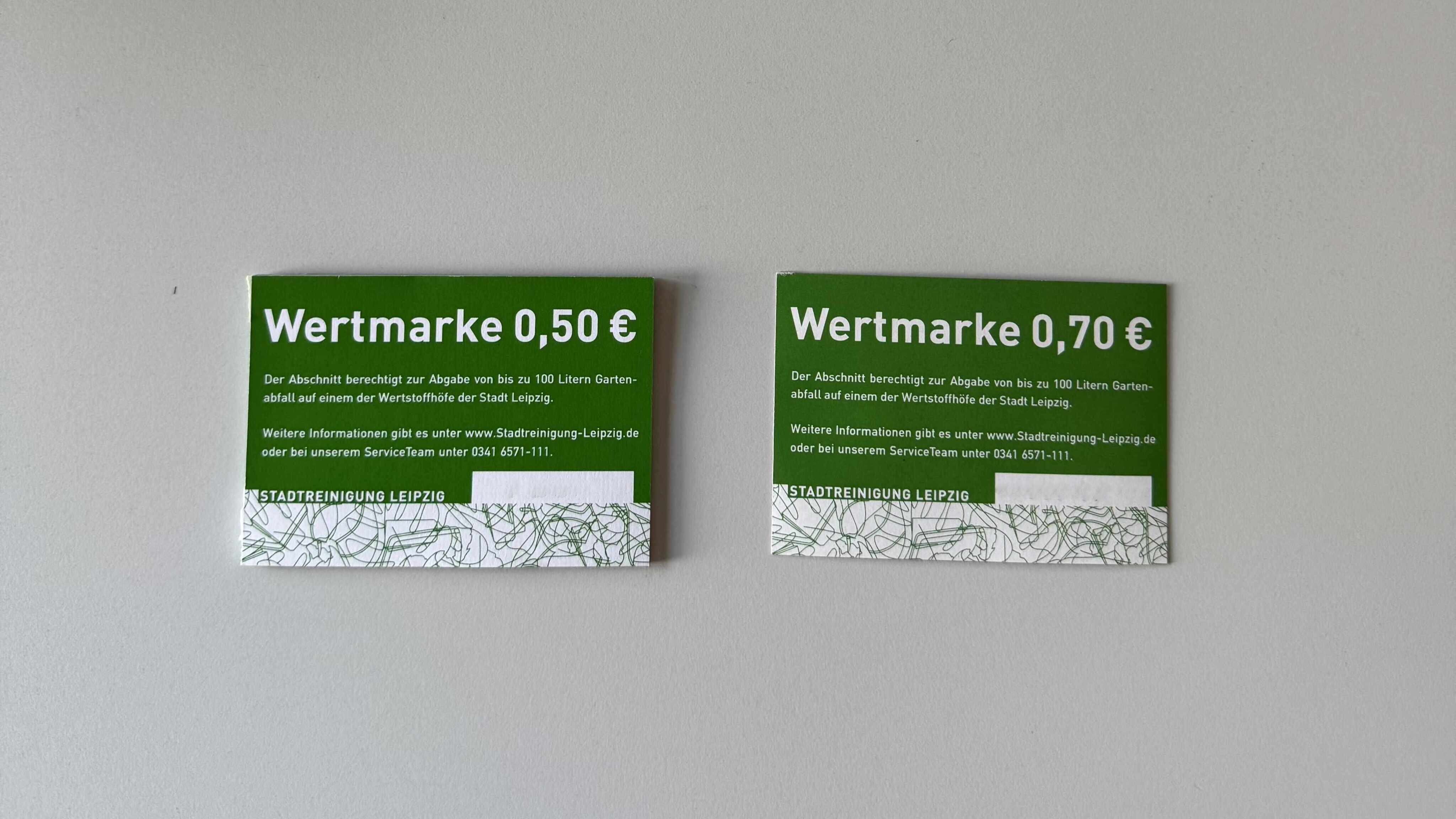 2 Wertmarken liegen nebeneinander auf dem Tisch. Wertmarke (links) hat einen Wert von 50 Cent. Wertmarke (rechts) hat einen Wert von 70 Cent.