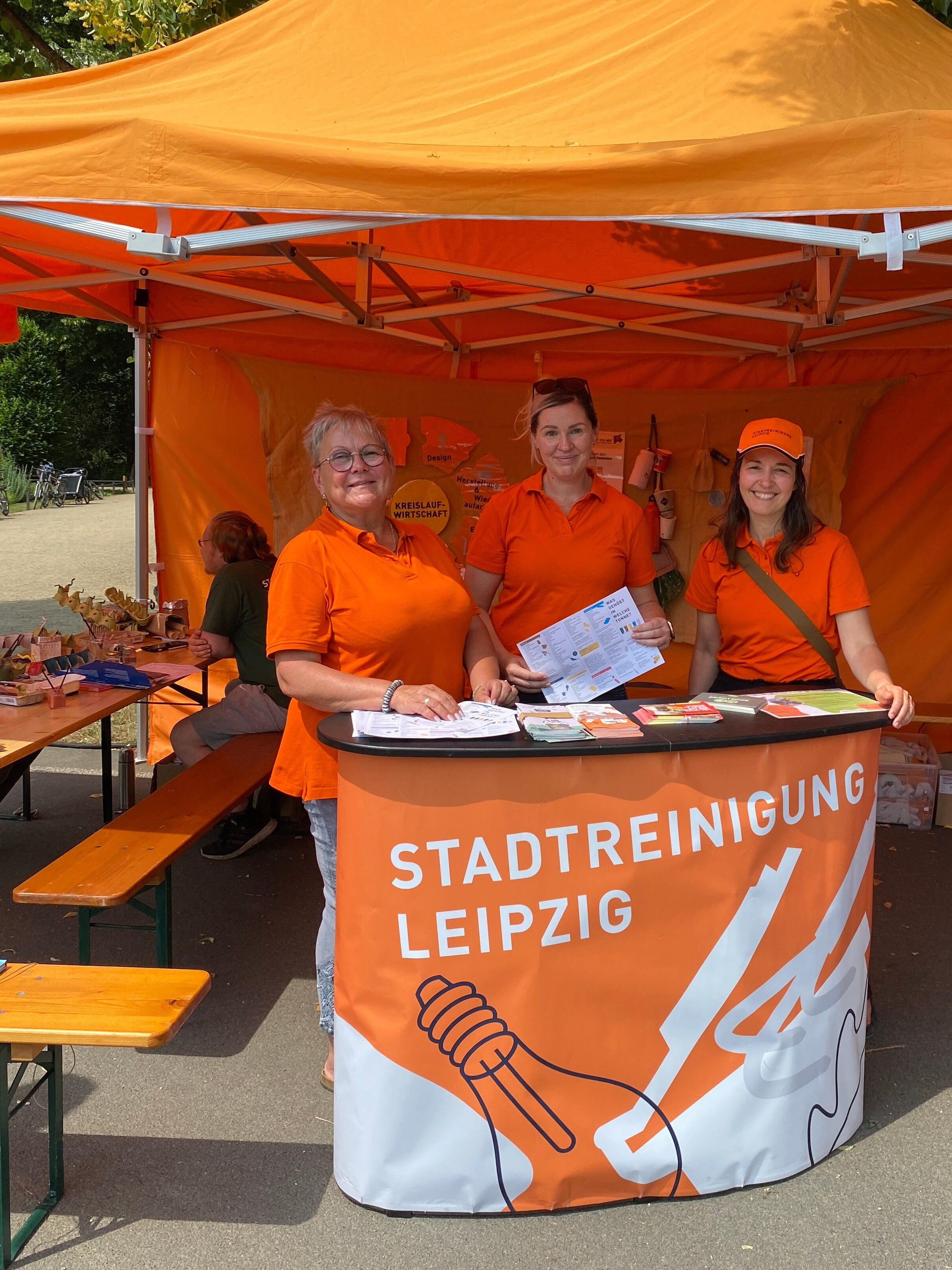 Zwei Mitarbeiterinnen der Stadtreinigung stehen f&uuml;r Fragen und Beratung in einerm Pavillon an einem Tisch