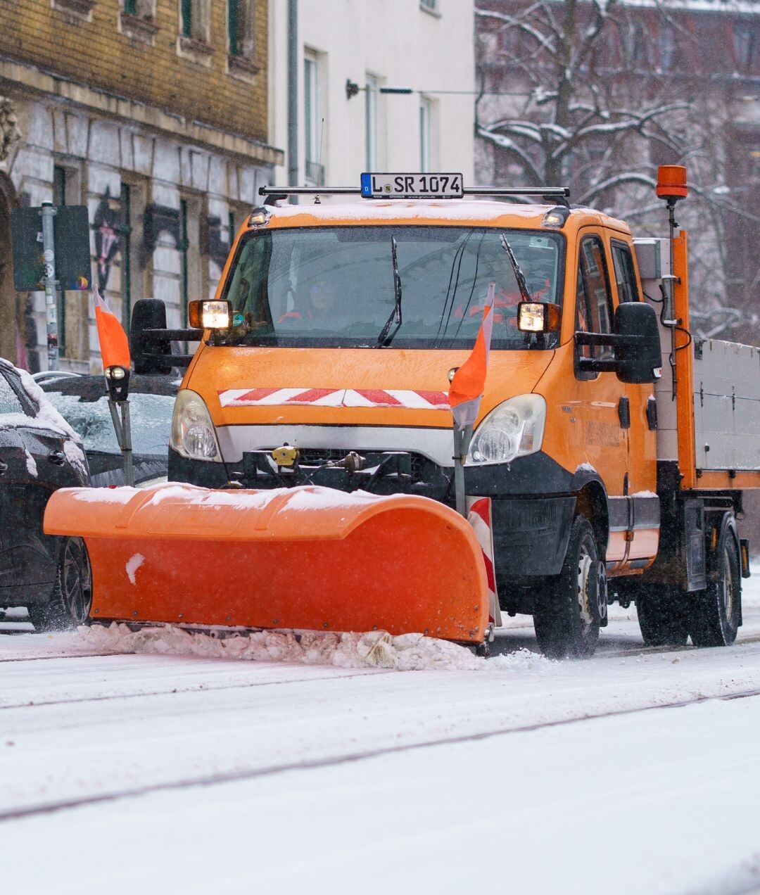 Winterdienstfahrzeug schiebt 10 cm Schnee auf Leipziger Stra&szlig;e.